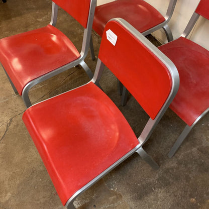 Red chairs with metal legs on a concrete floor