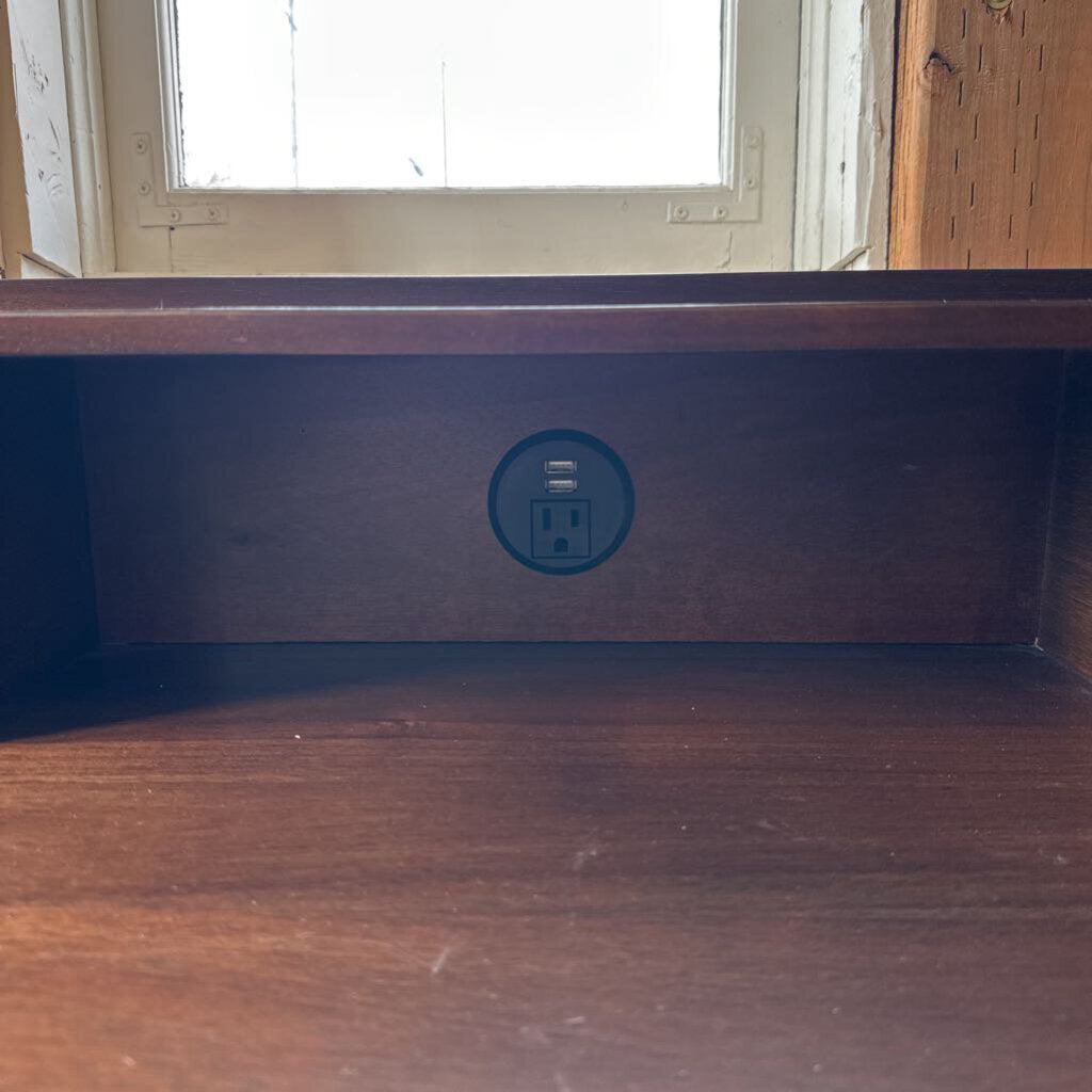 Wooden shelf with a power outlet symbol on a wooden surface.