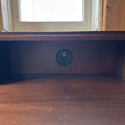Wooden shelf with a power outlet symbol on a wooden surface.