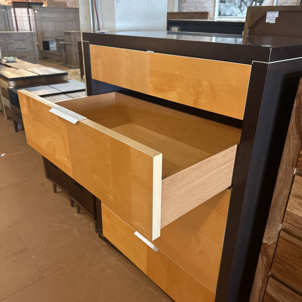 Wooden desk with open drawer in a showroom setting