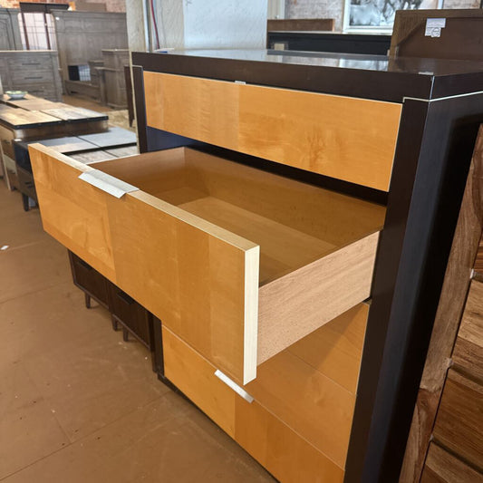 Wooden desk with open drawer in a showroom setting