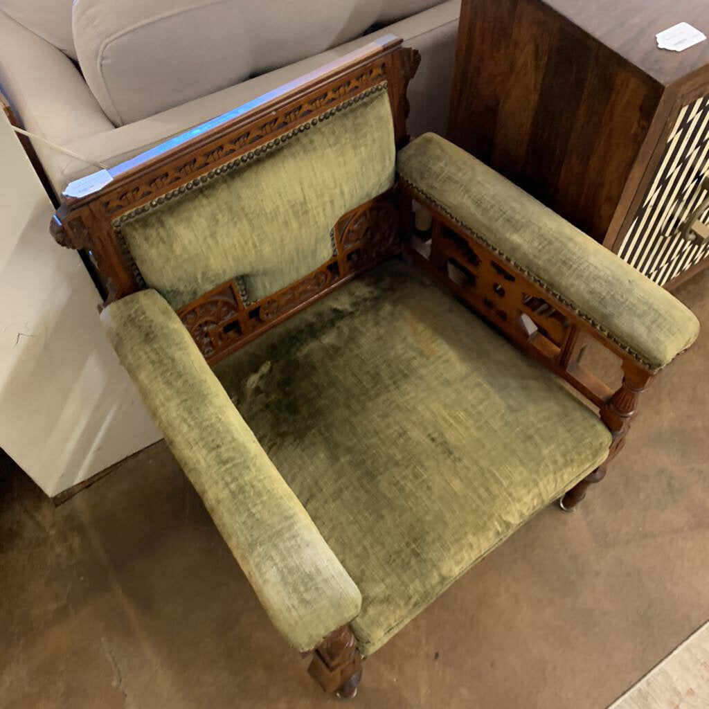 Vintage wooden chair with green cushioned seat and backrest in a room setting.