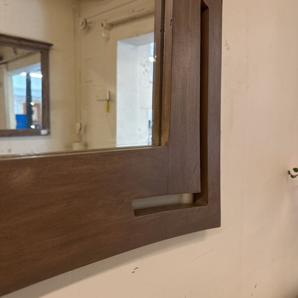 Wooden-framed mirror on a wall