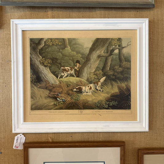 Framed artwork of a pastoral scene with people and animals on a textured wall.