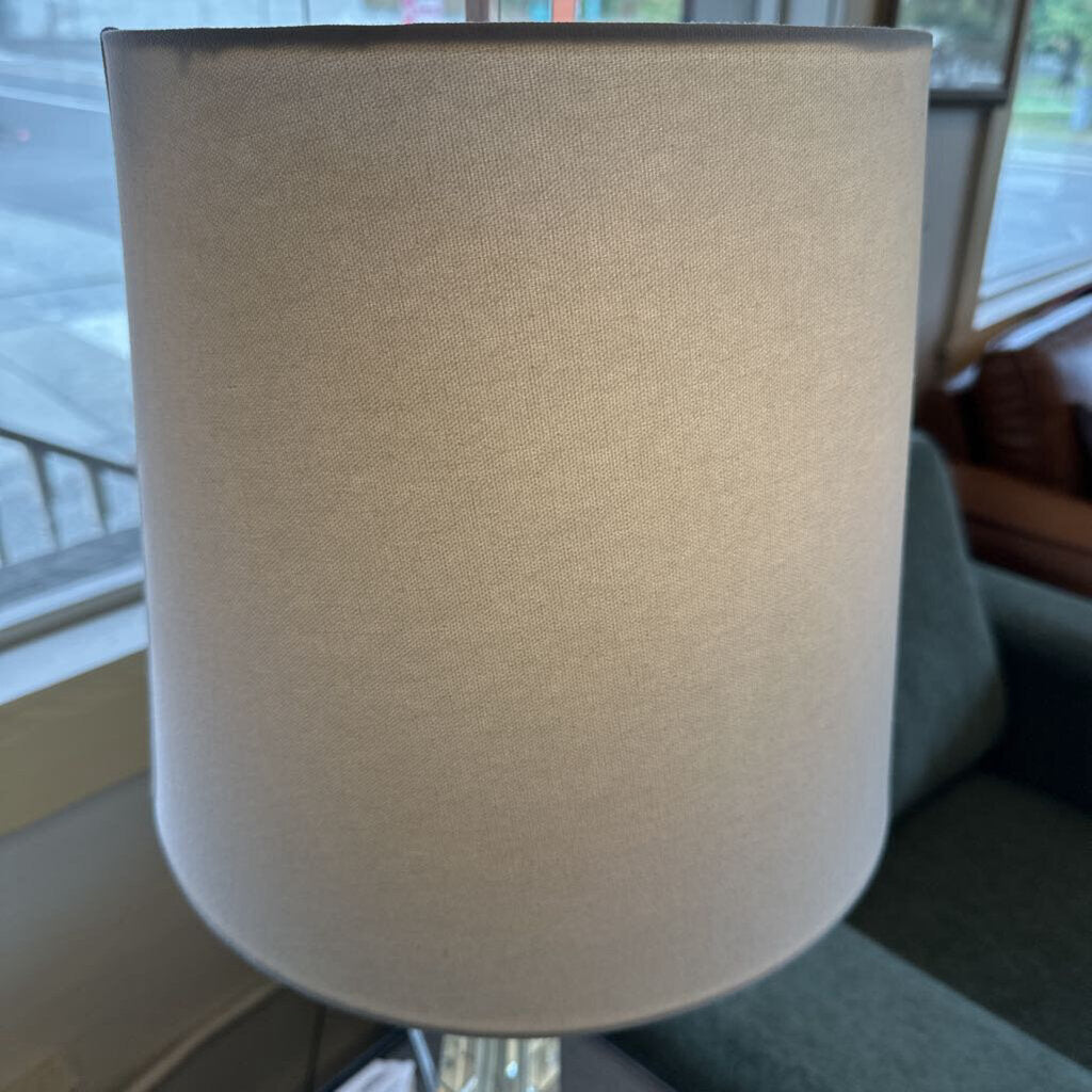 Close-up of a beige lampshade with a blurred indoor background