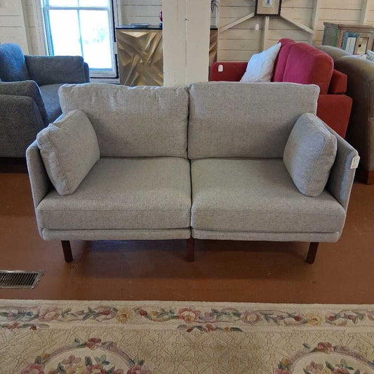 Gray sofa with cushions in a living room setting