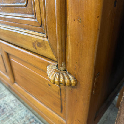 Close-up of a wooden door with a decorative gold handle.