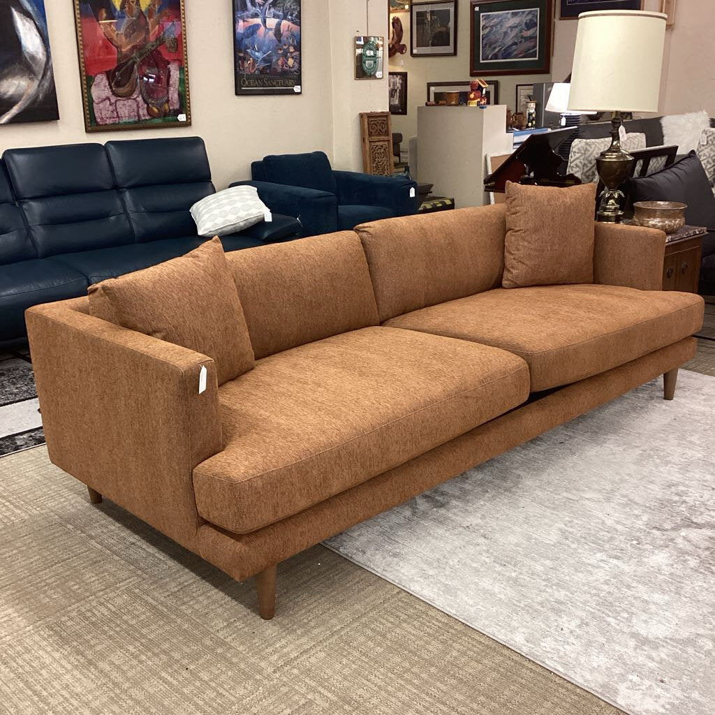 Brown sofa in a showroom with other furniture and decor.