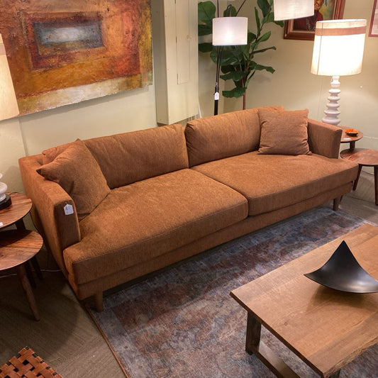 Brown sofa in a living room with a coffee table and decorative items.