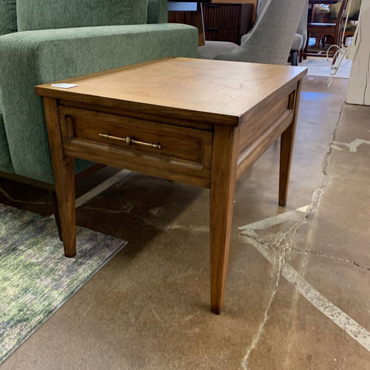 Wooden side table with a drawer in a room with furniture and a rug.