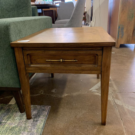 Wooden side table with a drawer in a room setting