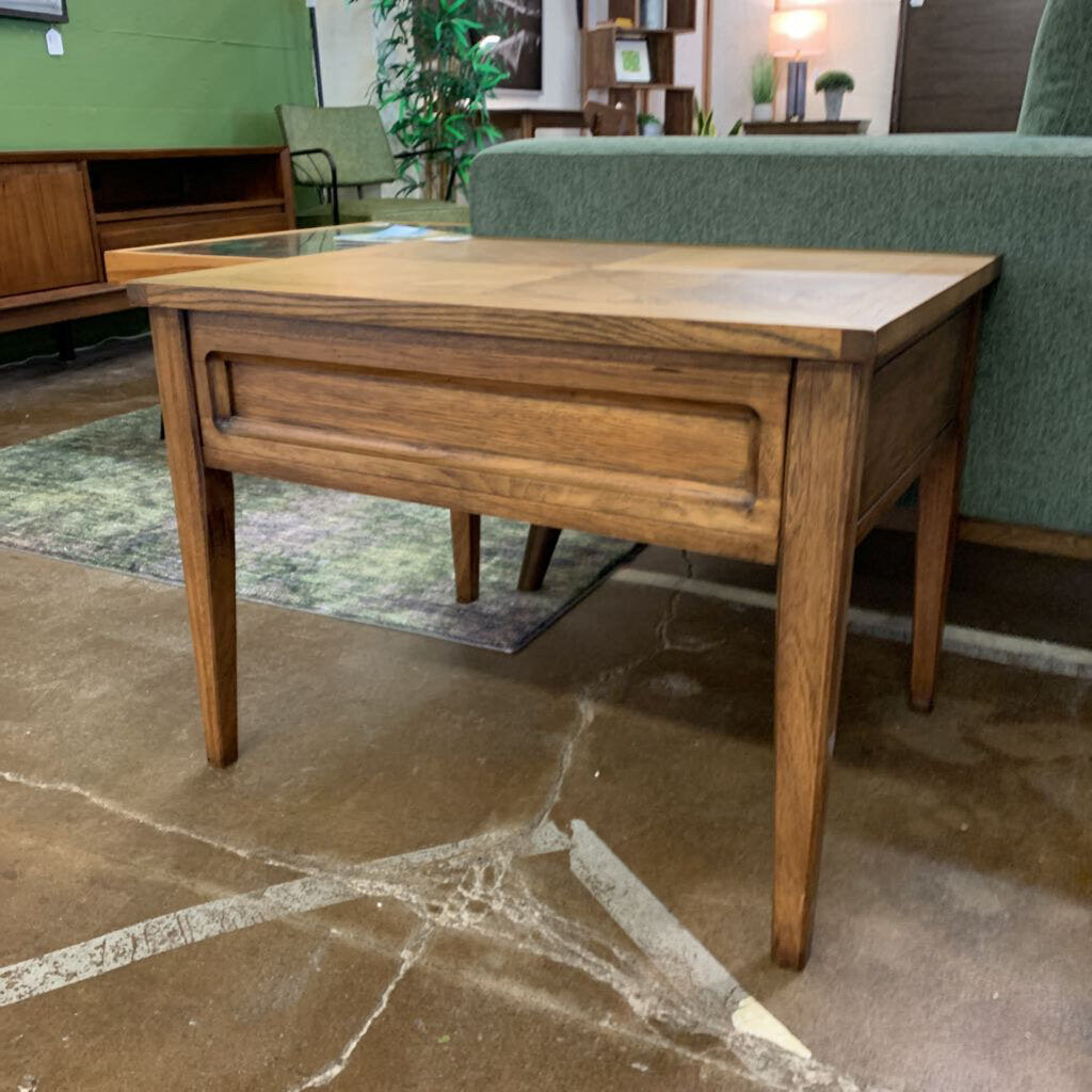 Wooden side table with a glass top in a room setting