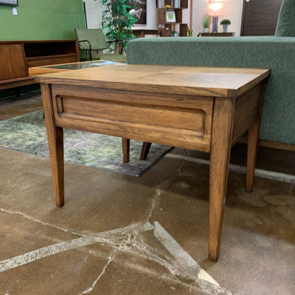 Wooden side table with a glass top in a room setting