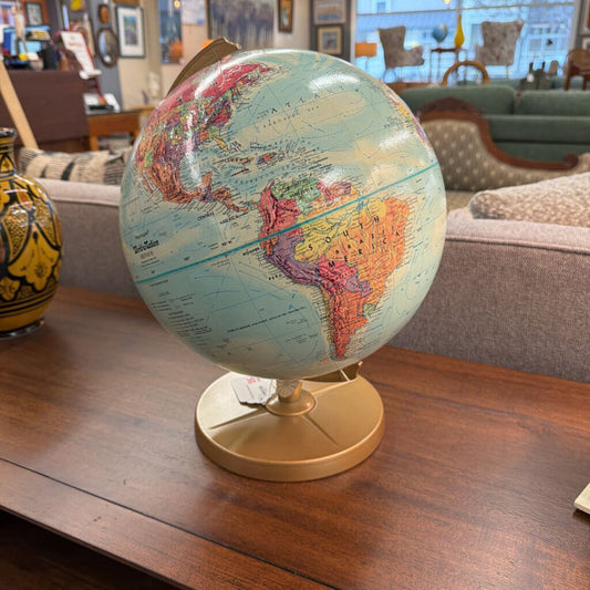 World globe on a wooden table with a living room in the background