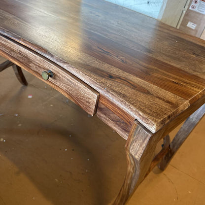 Wooden desk with a glass surface on a wooden floor