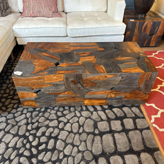 Wooden coffee table with a mosaic pattern in a living room setting.