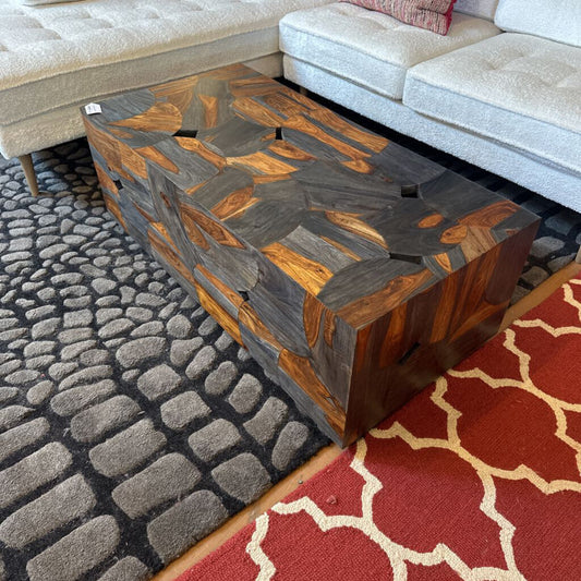 Wooden coffee table with a geometric pattern on a textured rug