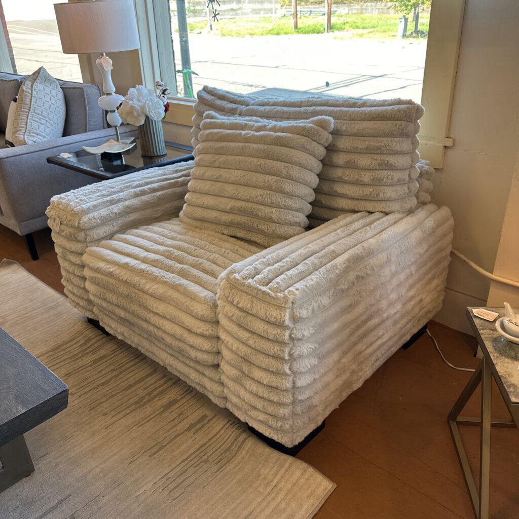 Beige textured armchair with cushions in a living room setting