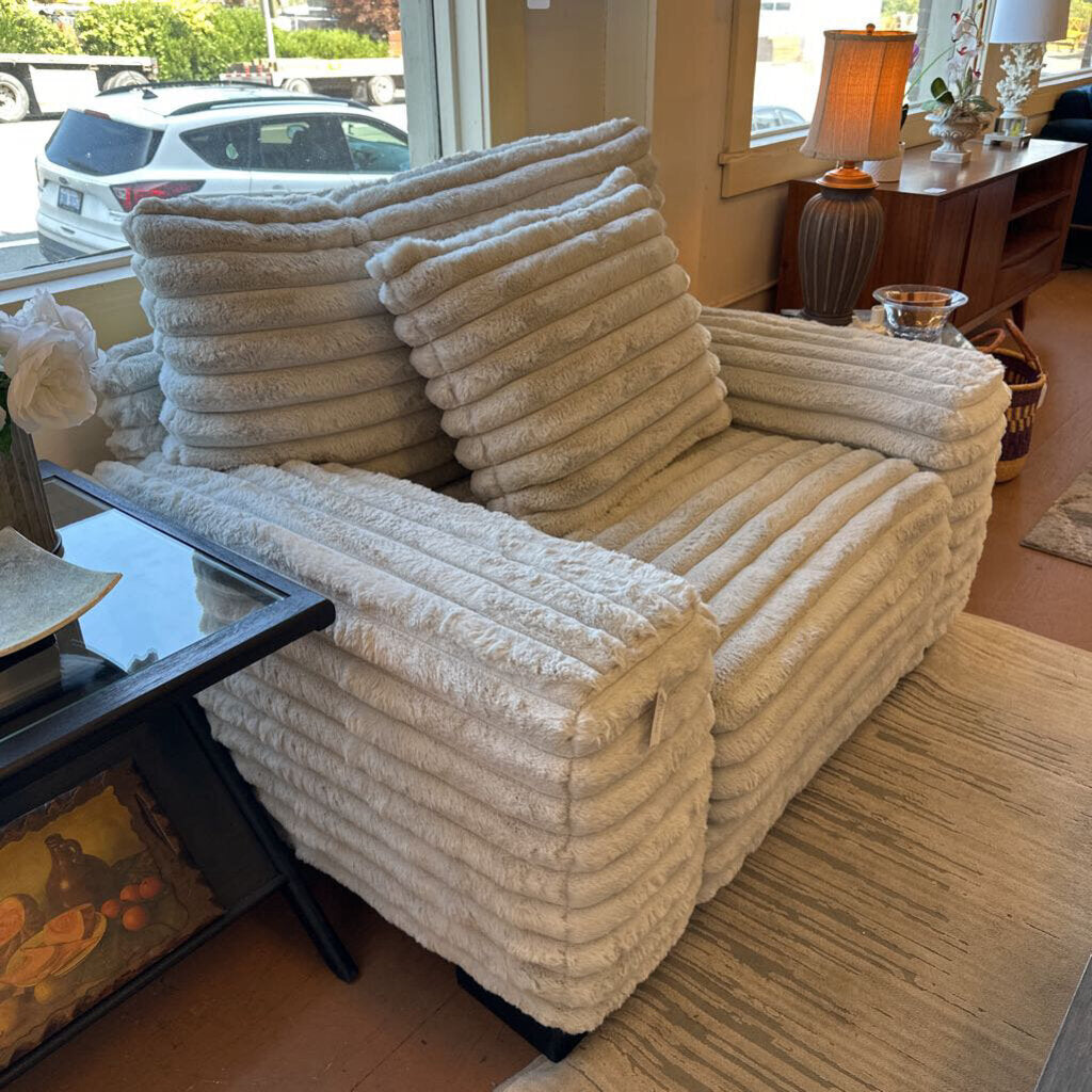 Beige textured sofa in a living room setting with a coffee table and decor items.
