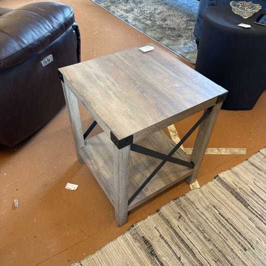 Wooden side table with metal legs on a brown floor