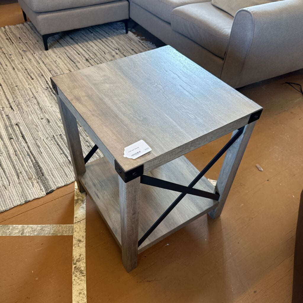 Small wooden side table with metal legs in a room setting
