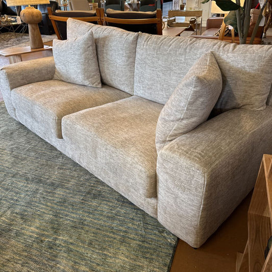 Beige sofa in a room with a rug and furniture