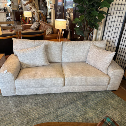 Beige sofa in a room with furniture and decor