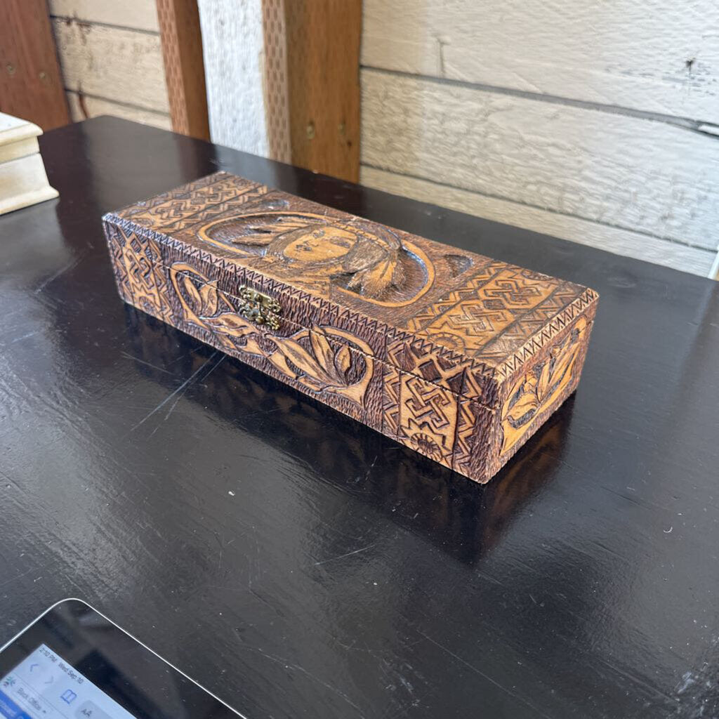 Decorative wooden box with intricate carvings on a dark surface