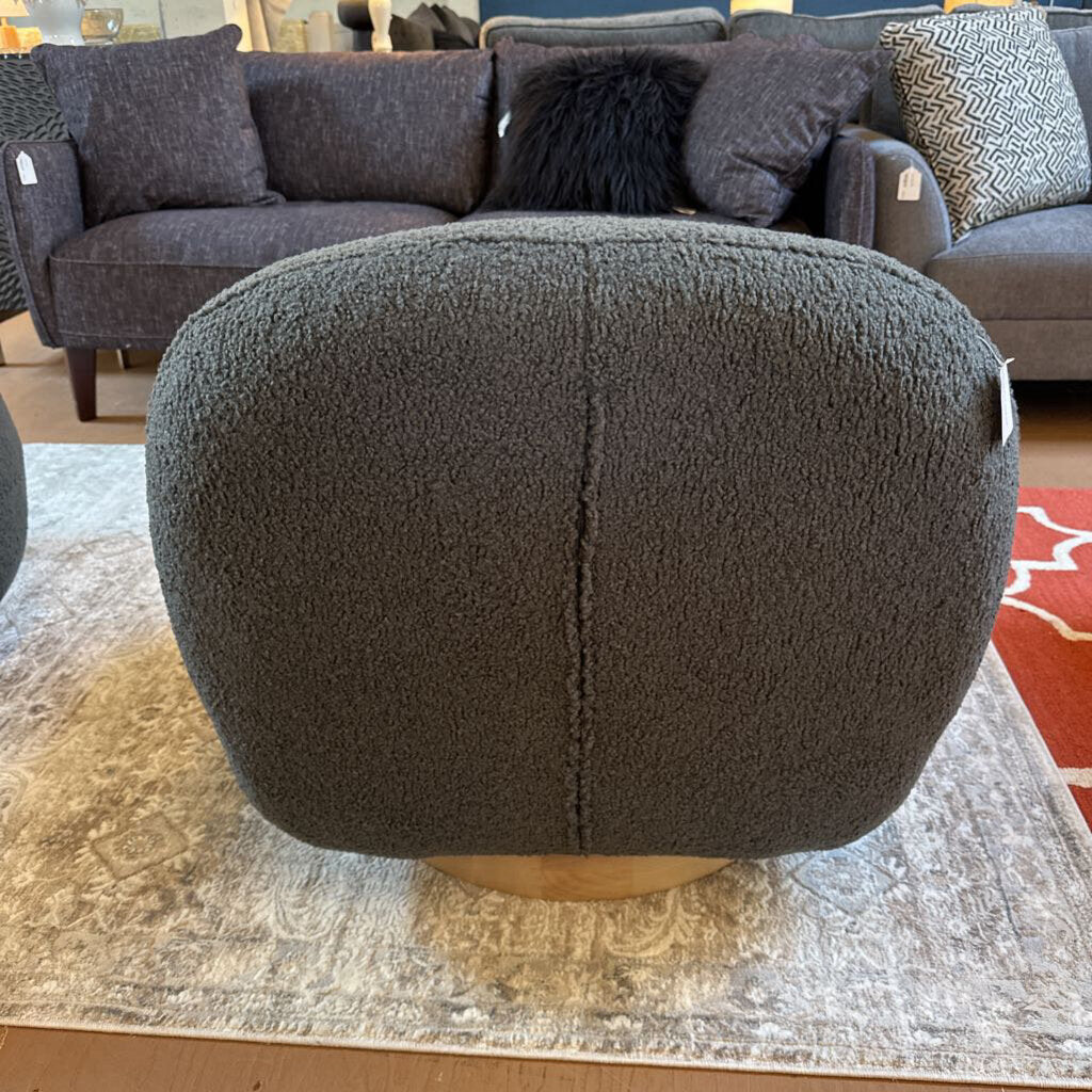 Gray textured ottoman in a room with a sofa and rug