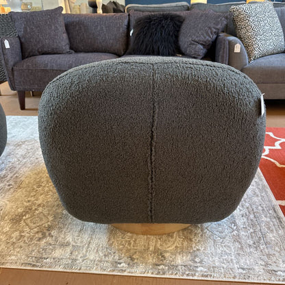 Gray textured ottoman in a room with a sofa and rug