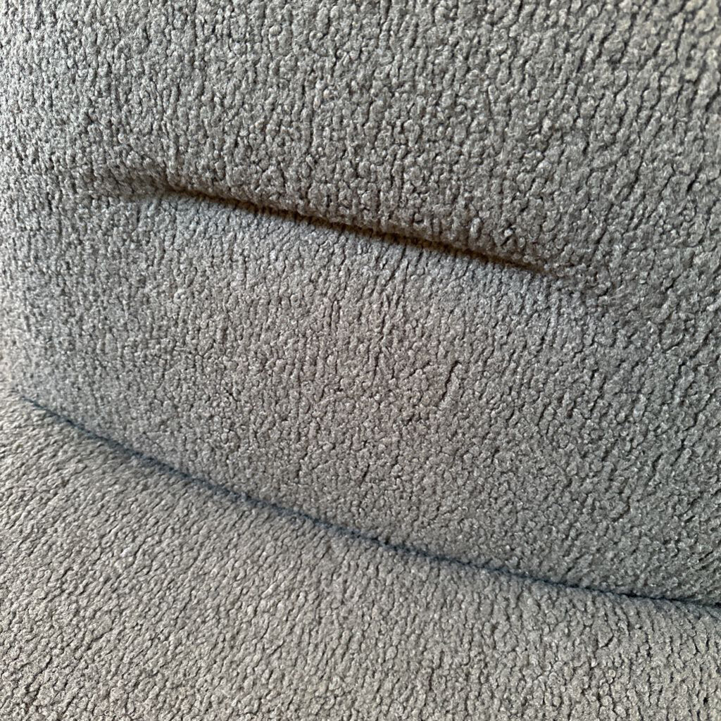 Close-up of textured gray fabric with a visible seam.