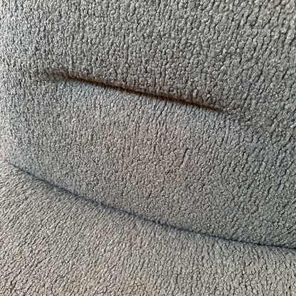 Close-up of textured gray fabric with a visible seam.