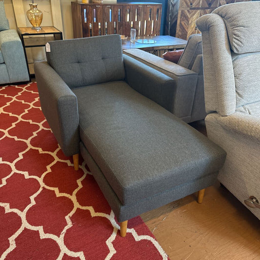 Gray sofa on a red patterned rug with a wooden floor