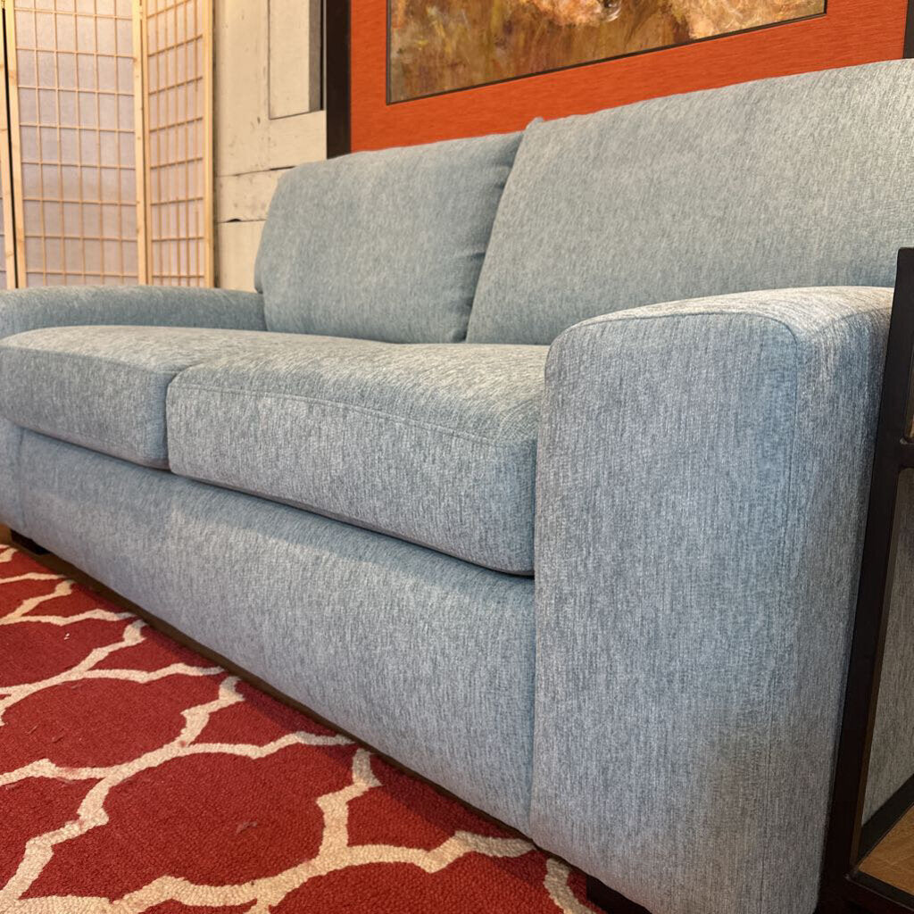 Gray sofa in a room with a red and beige patterned rug