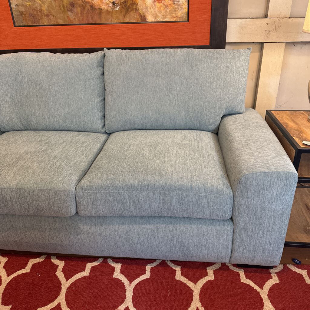 Gray sofa in a room with a red and white patterned rug