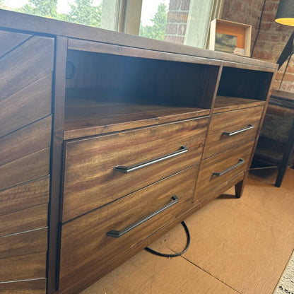 Wooden dresser with metal handles in a room setting