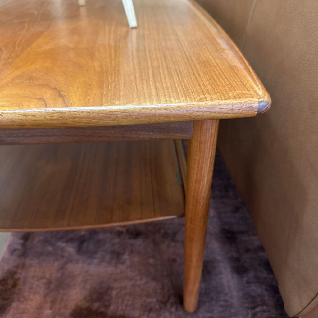 Wooden side table next to a brown sofa on a purple rug