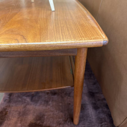 Wooden side table next to a brown sofa on a purple rug