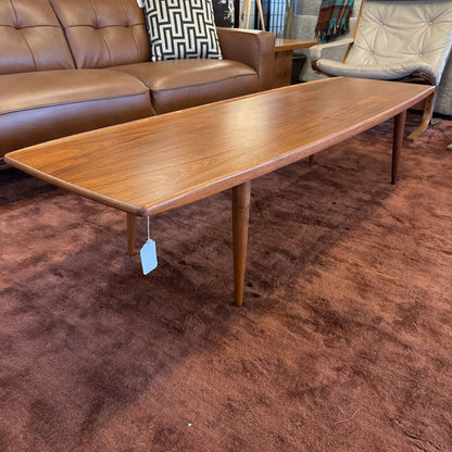 Wooden coffee table with a tag on a brown carpeted floor