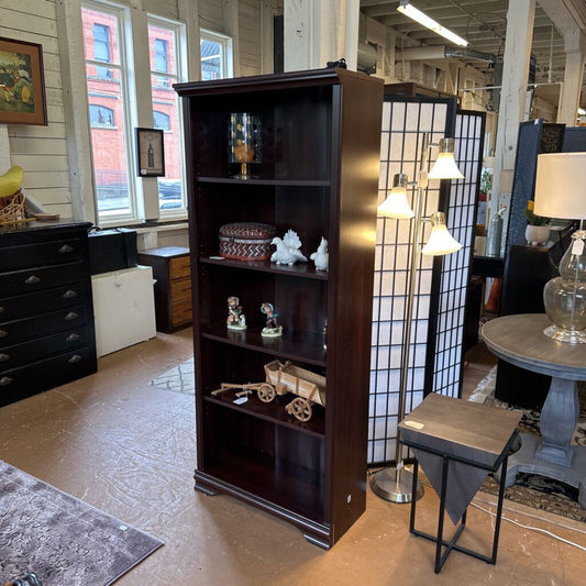 Wooden bookshelf in a room with furniture and decor