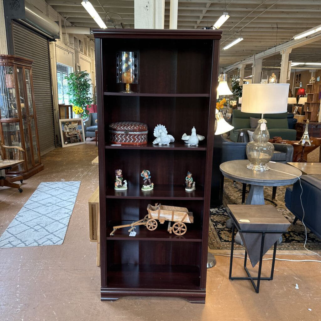 Dark wooden bookshelf with decorative items in a store setting