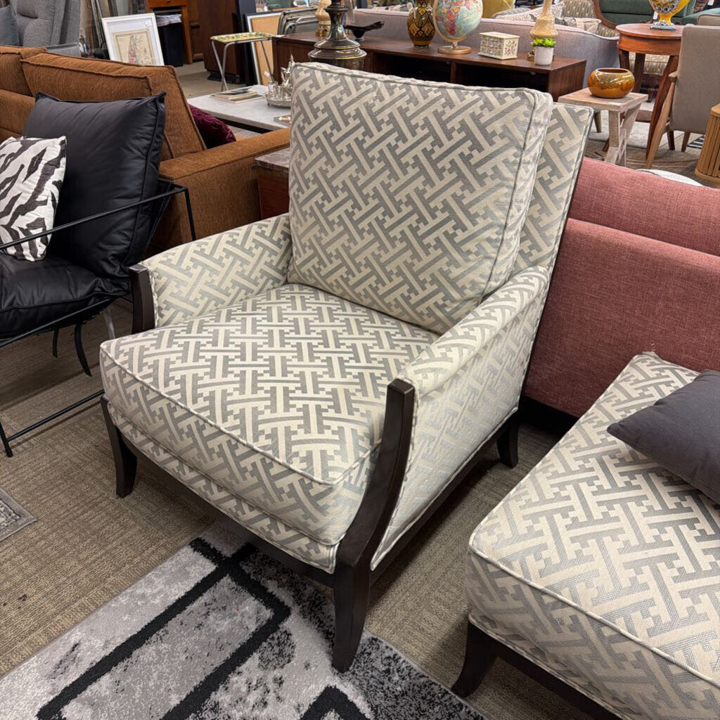 Patterned armchair and ottoman in a showroom setting with other furniture.