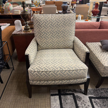 Patterned armchair in a furniture store setting with other chairs and tables.