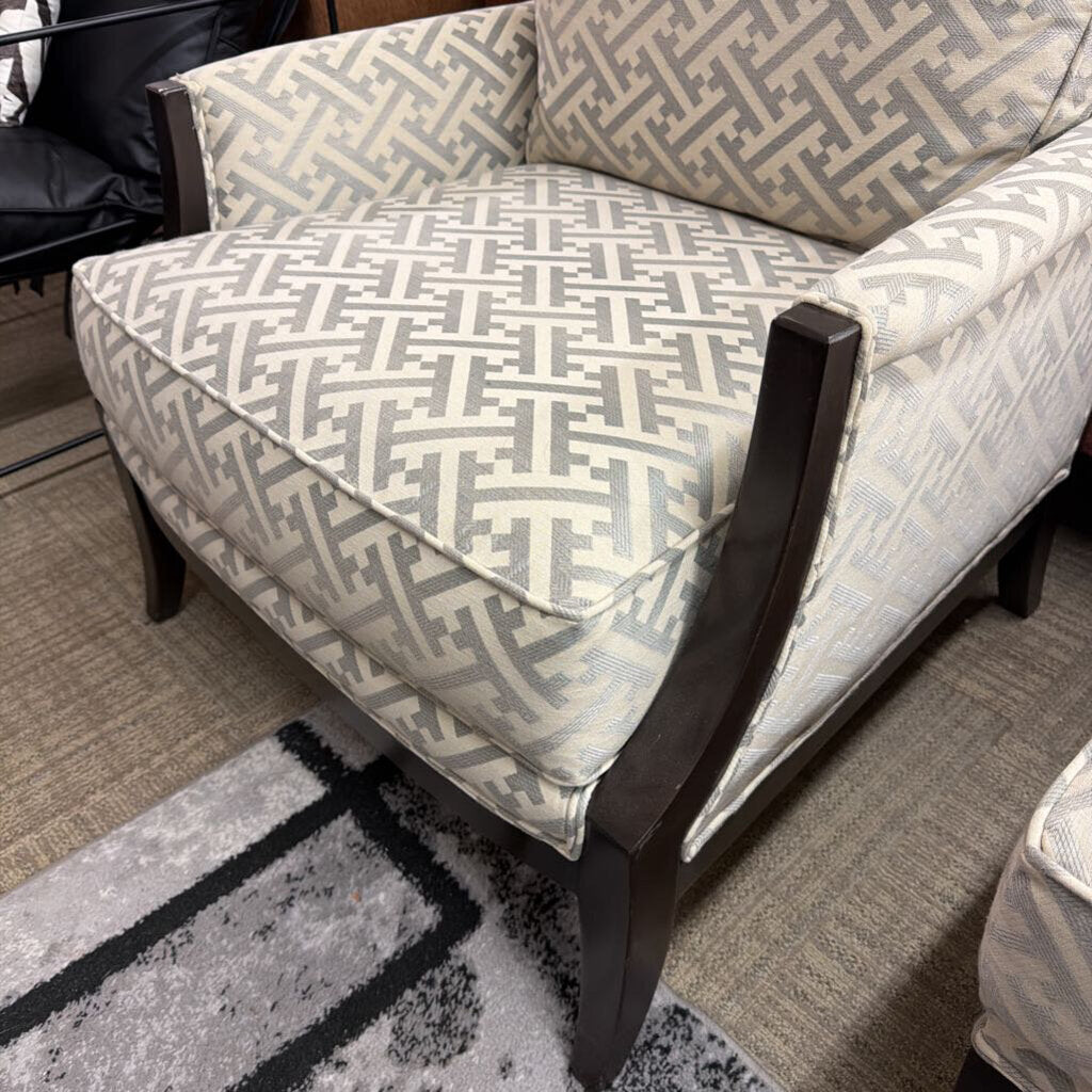 Patterned armchair with wooden legs on a carpeted floor