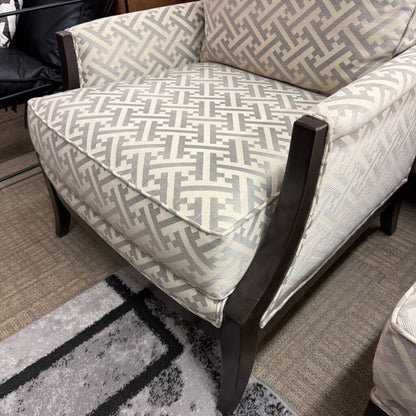 Patterned armchair with wooden legs on a carpeted floor