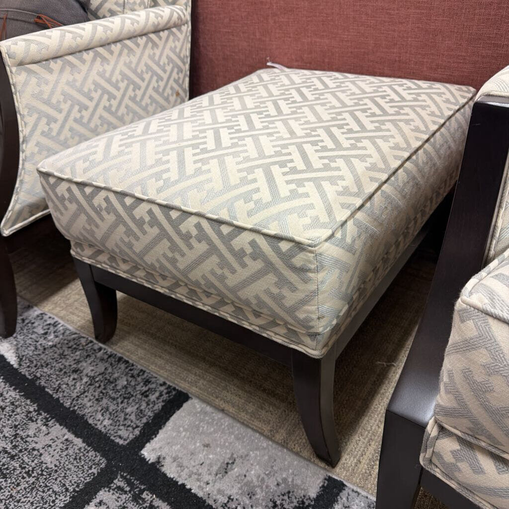 Patterned ottoman and chairs on a gray and black checkered rug