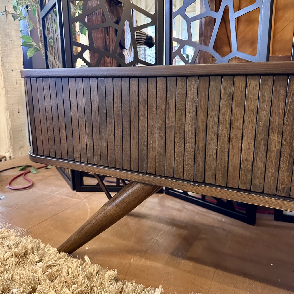 Wooden sideboard with decorative legs on a wooden floor