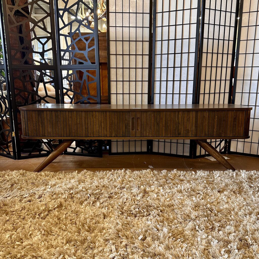 Wooden console table in a room with decorative screen and rug