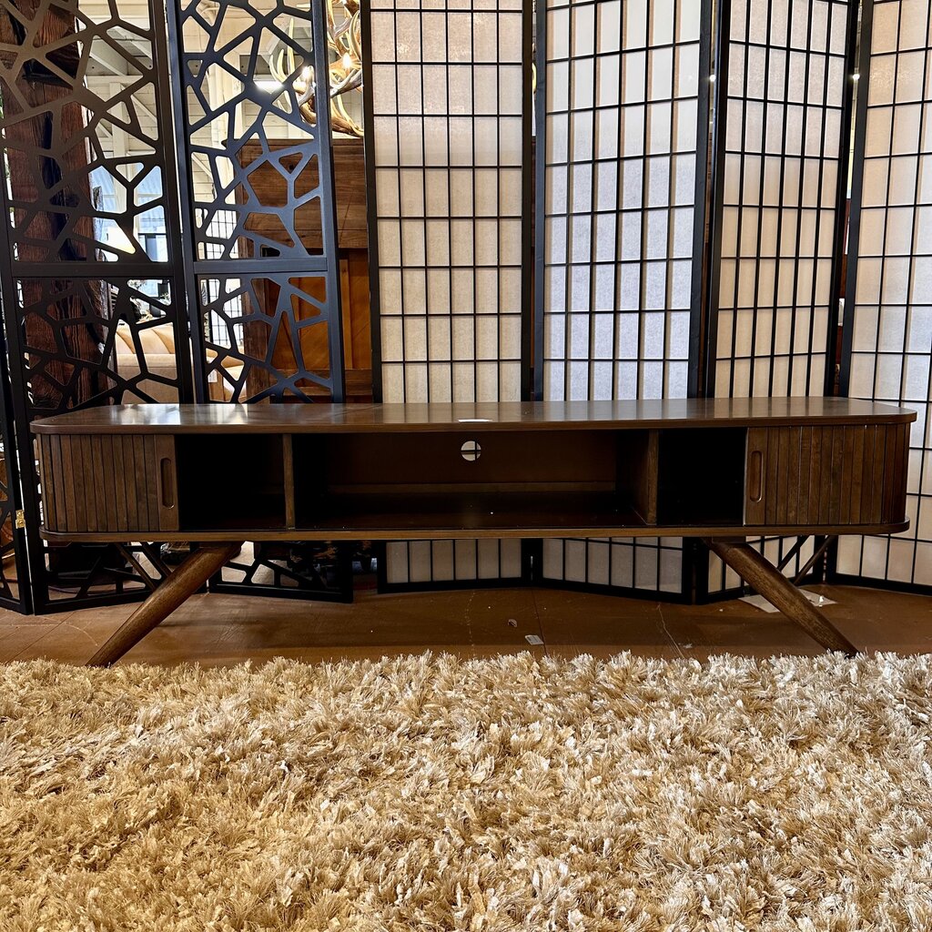 Wooden TV stand in a room with decorative screens and a textured rug.