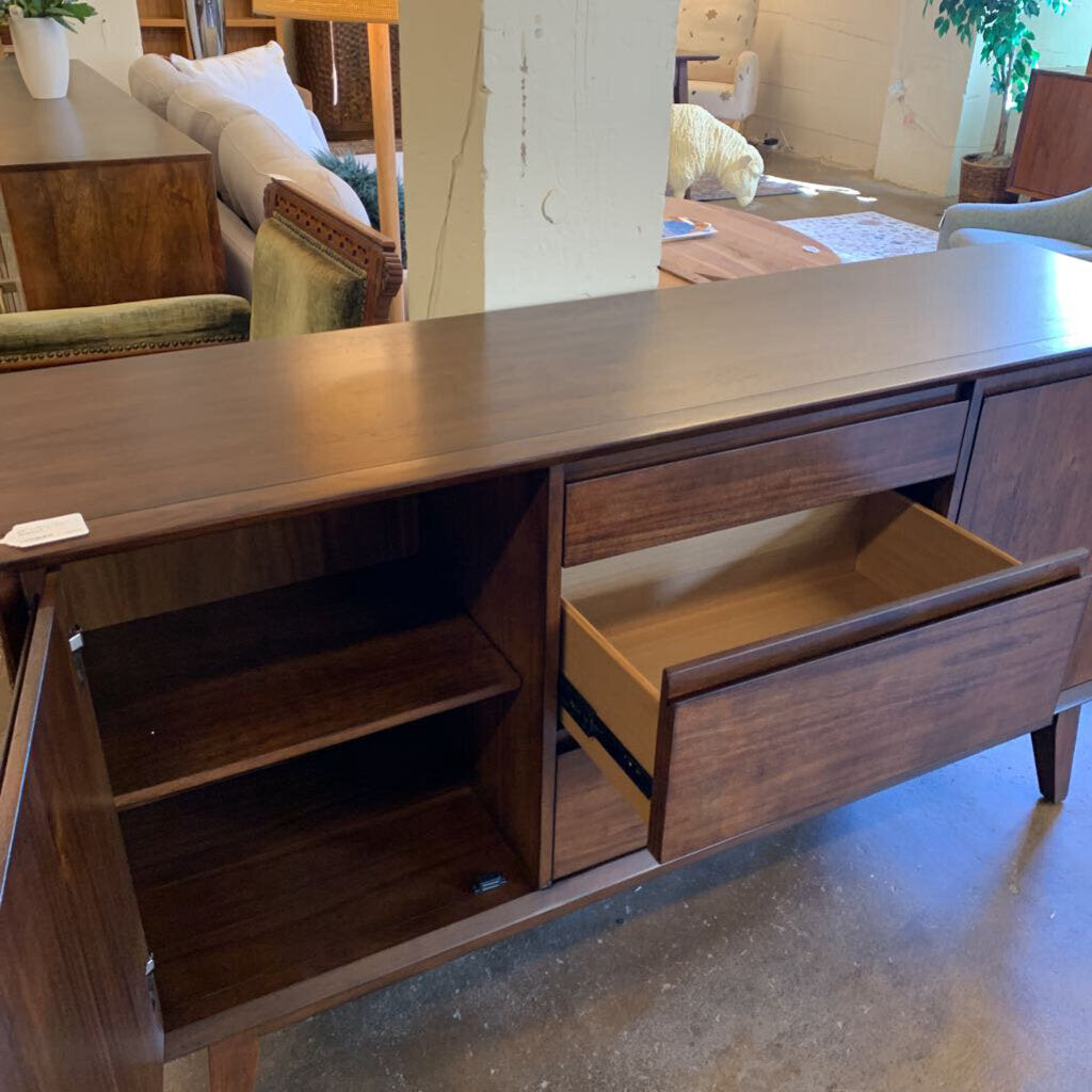 Wooden sideboard with open drawers in a room setting